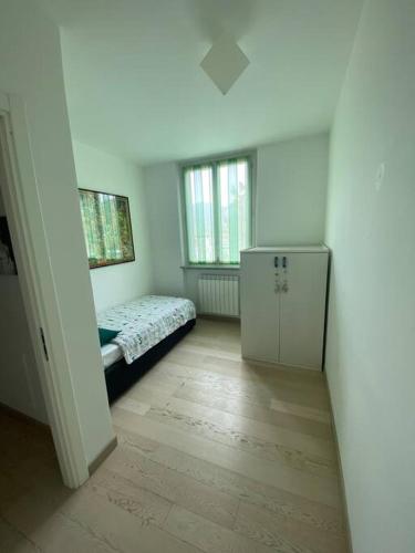 Cette petite chambre comprend un lit et une petite armoire. dans l'établissement Maison Minù, à Porto Ceresio