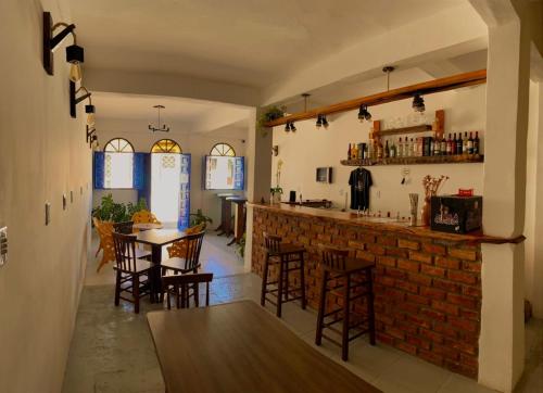 a room with a bar with chairs and a table at Pousada do beco in Caravelas