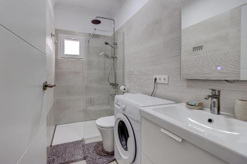 a white bathroom with a washing machine and a sink at Two bedroom apartment near the ocean in Playa de las Americas