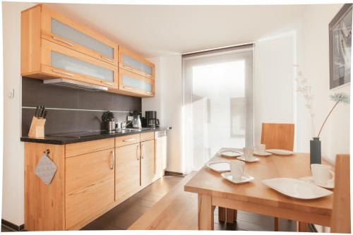a kitchen with wooden cabinets and a wooden table at Haus Calmsailing in Börgerende-Rethwisch