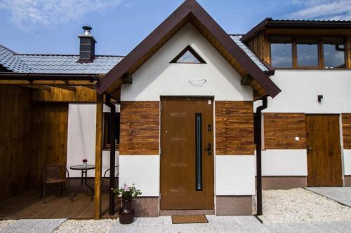 una casa con una puerta de madera y una mesa en Młyńskie Schody, en Staroscin