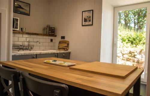 a kitchen with a wooden table and a counter top at Taobh na Mara in Kensaleyre