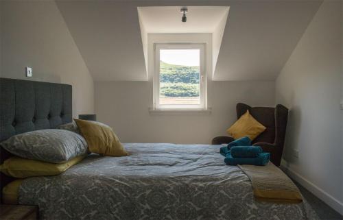 a bedroom with a bed with a teddy bear on it at Taobh na Mara in Kensaleyre