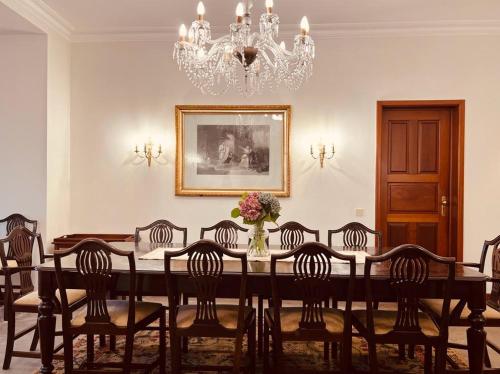 英雄港Quinta da Nasce Água的一间带桌椅和吊灯的用餐室