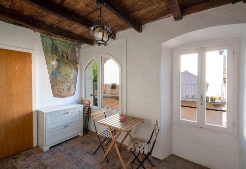 ein Esszimmer mit einem Tisch und 2 Fenstern in der Unterkunft Historical Caslano Apartments - Happy Rentals in Caslano
