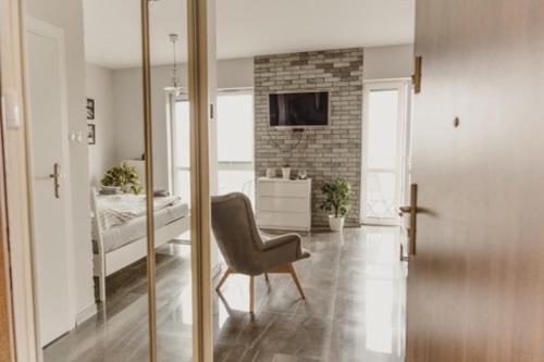 salon z krzesłem i sypialnia w obiekcie Łódź Fabryczna Apartament w Łodzi