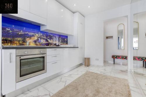 cocina con paredes blancas y fogones horno superior en Stylish 1BR Penthouse w Panoramic Views & BBQ by 360 Estates, en Il-Gżira
