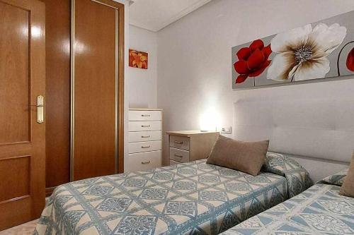 ein Schlafzimmer mit einem Bett, einer Kommode und einer Schublade in der Unterkunft Apartamento Maria Salamanca 8 in Santa Pola