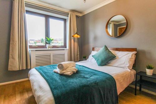 um quarto com uma cama com um espelho e uma janela em Comfortable 2 Bedroom House with Free Parking em Nottingham