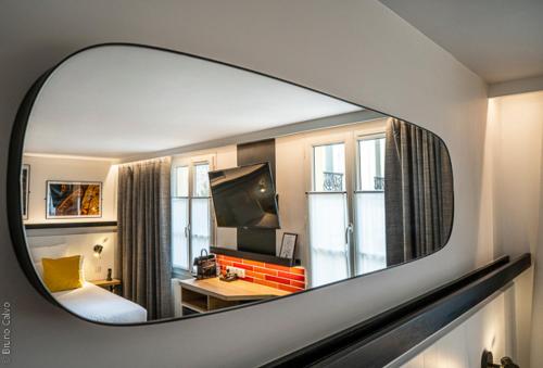 a mirror reflection of a room with a bedroom at 26 Faubourg - Ex-Hotel de Reims in Paris