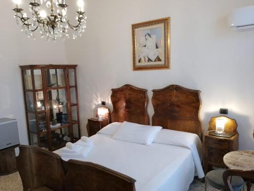 a bedroom with a white bed and a chandelier at Glam Resort G H O S T E L in La Spezia