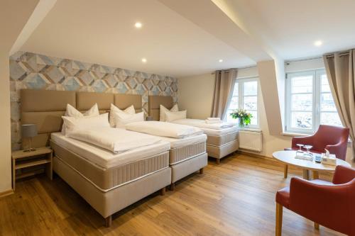 a bedroom with two beds and a table and chairs at Hubertus Hof in Goslar