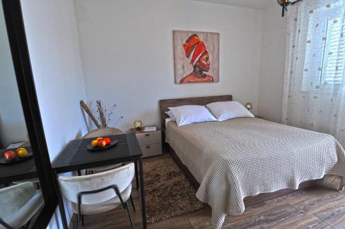 a small bedroom with a bed and a table with a table at Villa Katarina in Dubrovnik