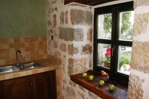 a kitchen with a sink and a window with apples on a counter at House Marin in Starigrad