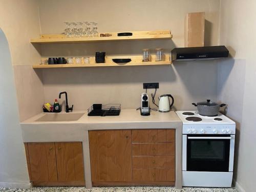 a small kitchen with a stove and a sink at Traditional Cosy Home in Ios Chora