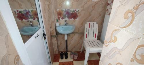a small bathroom with two sinks and a chair at Mehdi House in Chefchaouen