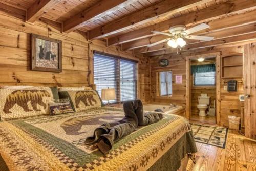 um quarto com uma cama num chalé de madeira em Lazy Bear Cabin em Sevierville