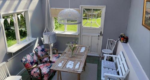 Cette petite chambre comprend une table, des chaises et des fenêtres. dans l'établissement Farmhouse Marielund, à Mariannelund