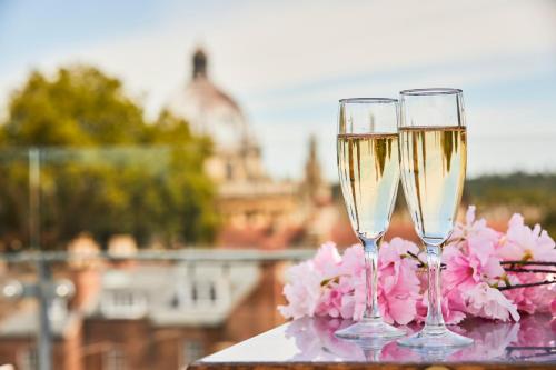 two glasses of champagne sitting on a table with flowers at The Union Penthouse in Oxford