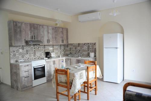een keuken met een tafel en stoelen en een koelkast bij SAN FLORAN in Áyios Flóros