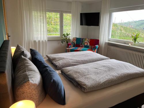 a bedroom with two beds and a chair and a window at Revier No11 in Durbach