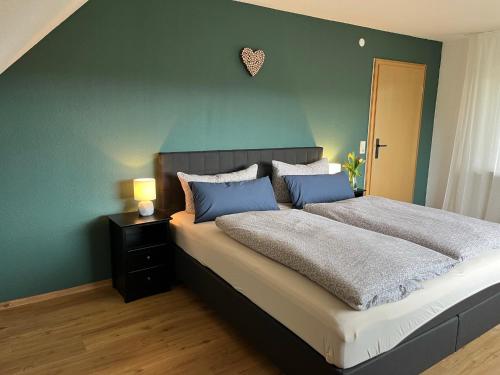 a bedroom with a large bed with a blue wall at Revier No11 in Durbach