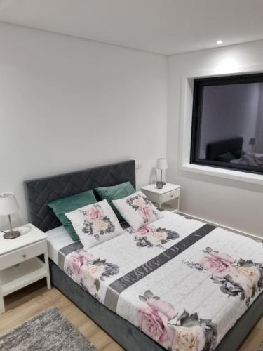 a bedroom with a bed with pink flowers on it at Blue Beach Apartment - Caminhos de Santiago-Airport in Praia de Angeiras