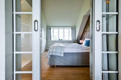 a bedroom with a bed and a window at Kontorhaus Keitum in Keitum