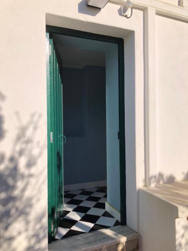 una puerta verde con suelo blanco y negro a cuadros en Casa Martins Country Apartment No5 en Freiria