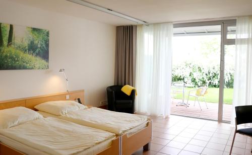 a bedroom with a bed and a sliding glass door at Seminarhotel in der Manfred-Sauer-Stiftung in Lobbach