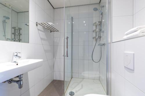 uma casa de banho com uma cabina de duche em vidro e um lavatório. em Amrâth Apart-Hotel Schiphol Badhoevedorp em Badhoevedorp