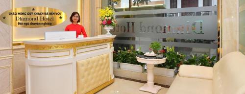 a woman standing at a counter in a flower shop at Diamond Hotel Ha Noi in Hanoi