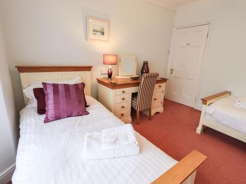 a bedroom with a bed and a desk with a desk at Gildabrook Cottage in Bowness-on-Windermere