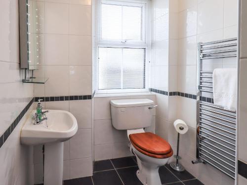 a white bathroom with a toilet and a sink at Gildabrook Cottage in Bowness-on-Windermere