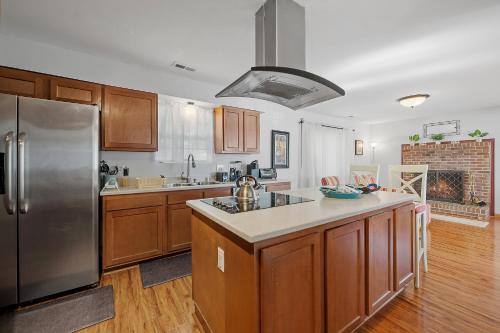 a kitchen with wooden cabinets and a stainless steel refrigerator at Perfect Private Getaway Minutes to Virginia Beach! in Virginia Beach