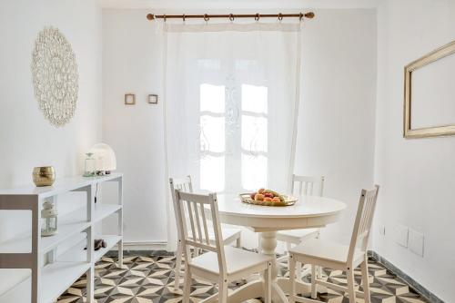 une salle à manger blanche avec une table et des chaises blanches dans l'établissement Attico e Nuvole, à Monte Marcello