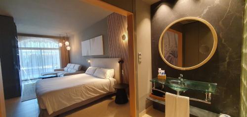 a bedroom with a bed and a mirror and a sink at Miami Mar - Boutique Hotel & Restaurante in Sant Carles de la Ràpita