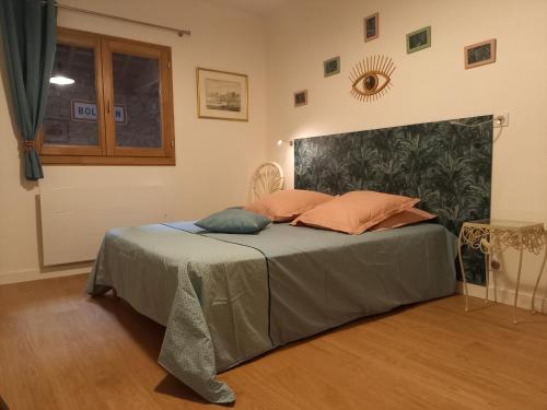 1 dormitorio con 1 cama con 2 almohadas en La Vie du Bief, en Bolozon
