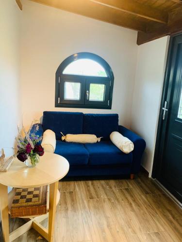 a living room with a blue couch and a table at Villa Matsika in Moudhros