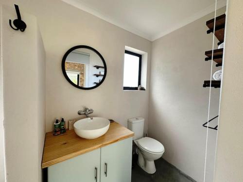 a bathroom with a sink and a toilet at Stylish Garden Retreat in Cape Town