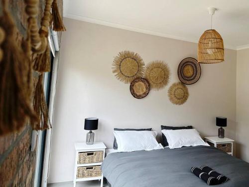 a bedroom with a bed with two night stands and baskets on the wall at Stylish Garden Retreat in Cape Town