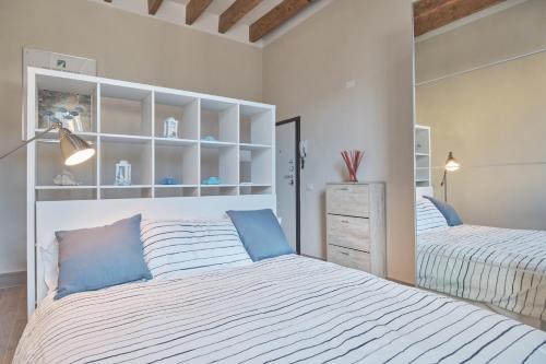 twee bedden in een slaapkamer met wit en blauw bij Green Coast House 3 in Piombino