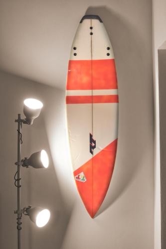 een surfplank aan een muur naast een lamp bij Green Coast House 3 in Piombino