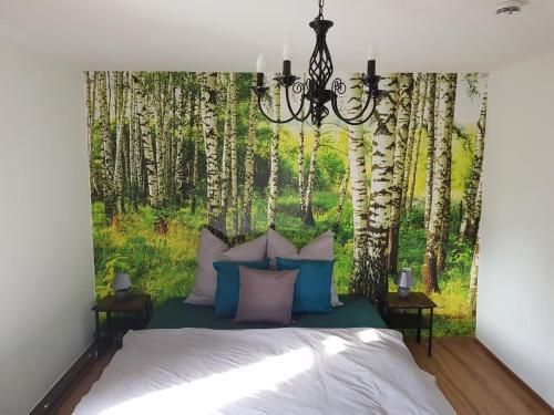1 dormitorio con 1 cama con un mural de árboles en Ferienhaus Relax Ranch en Hiltpoltstein