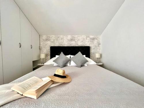 een slaapkamer met een bed met een hoed en boeken bij Apartments Pera in Hvar