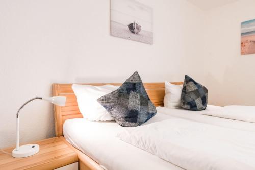 1 dormitorio con 2 camas con almohadas en Haus-Kaept-n-Hein-Cors, en Wenningstedt