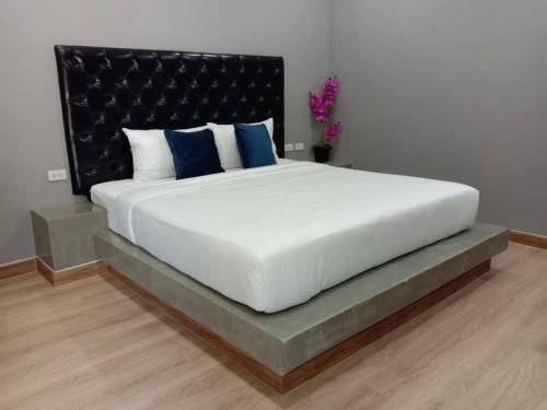 a bedroom with a large white bed with blue pillows at Sawasdee​ Buriram​ Resort in Buriram