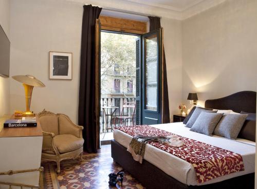 um quarto com uma cama, uma cadeira e uma janela em We Boutique Hotel Barcelona em Barcelona
