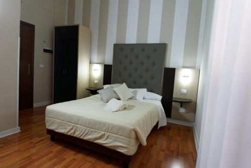 a bedroom with a large bed with two lamps at Hotel Sant'Elia in Messina