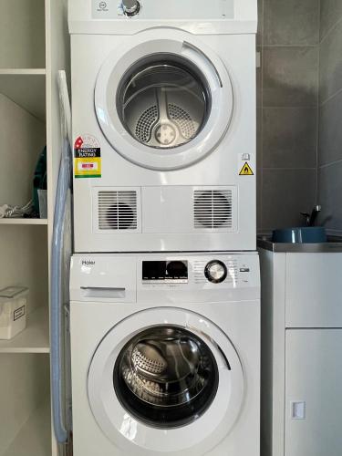 a washing machine and a dryer in a kitchen at Queensview168 Apartments Moonee Ponds in Melbourne